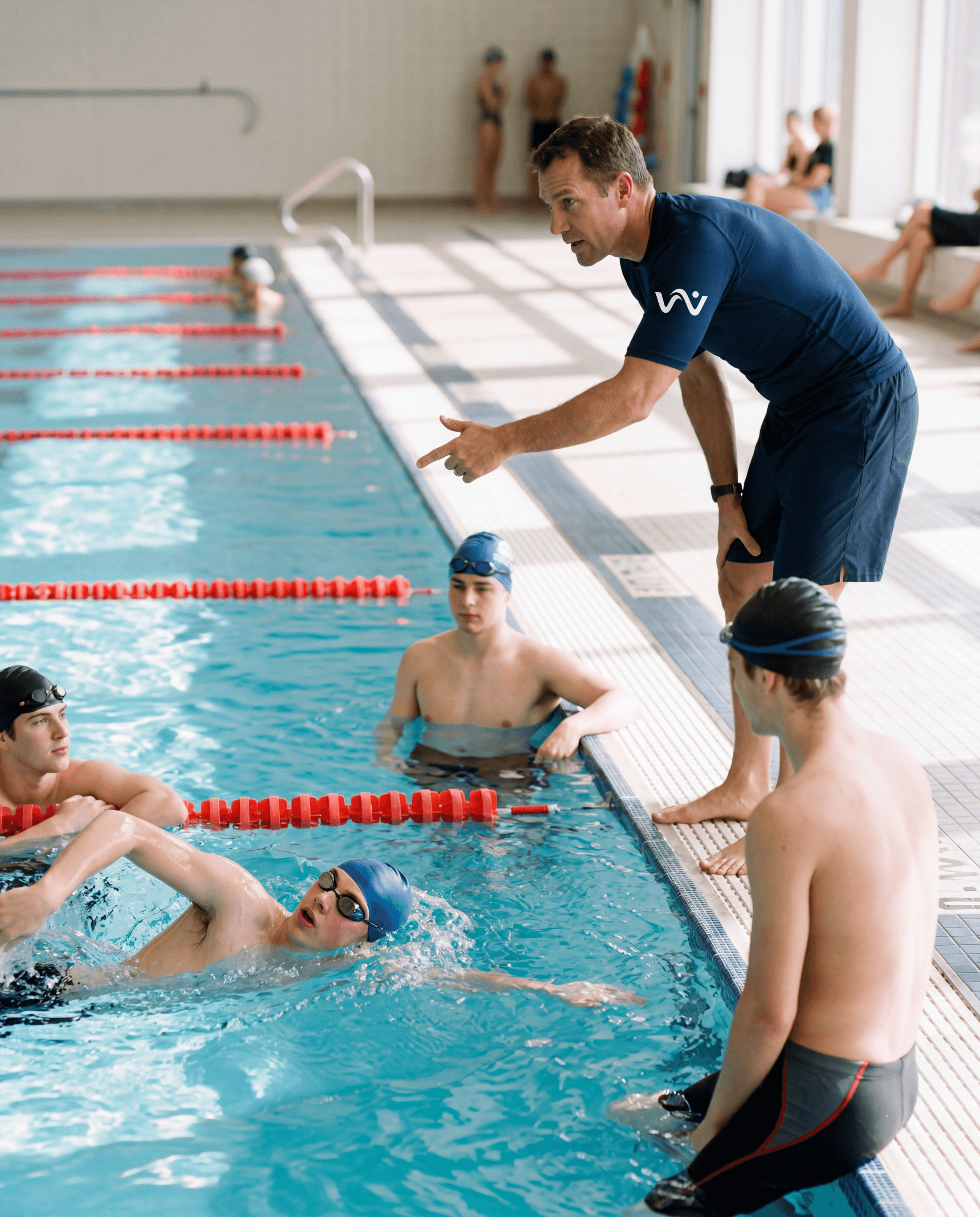 Instructor with swimmer at pool edge